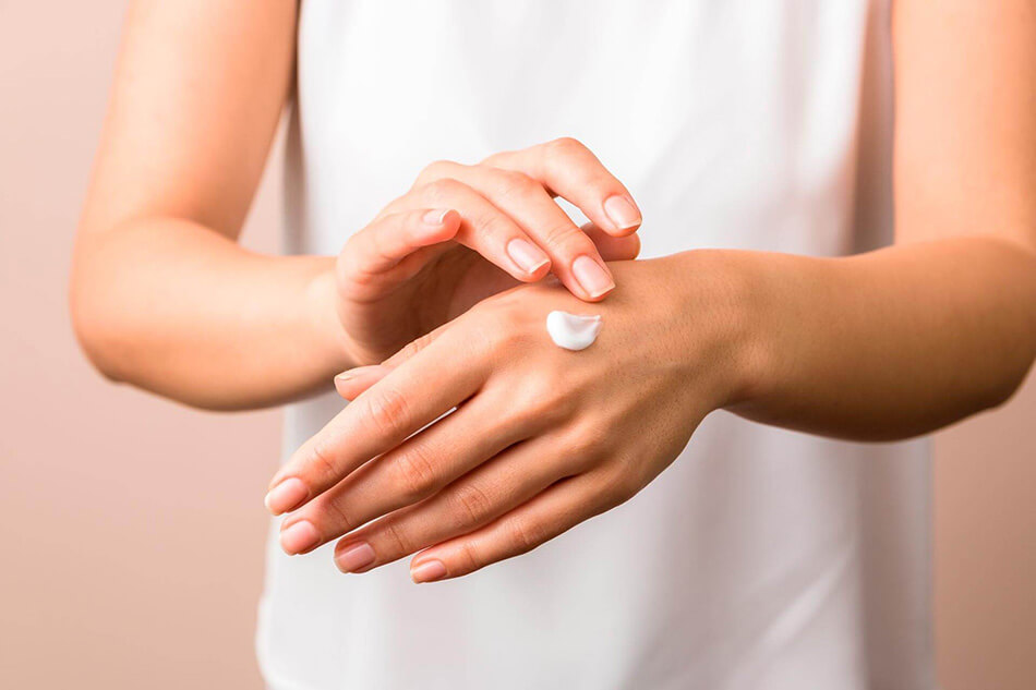 Mulher aplicando medicamento para dermatite atópica
