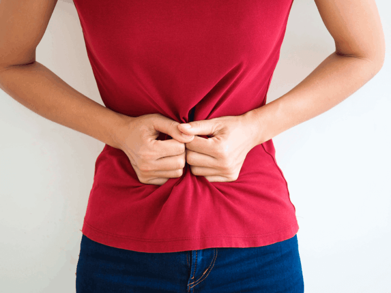 Mulher com fortes dores no abdômen provocadas pela inflamação no intestino