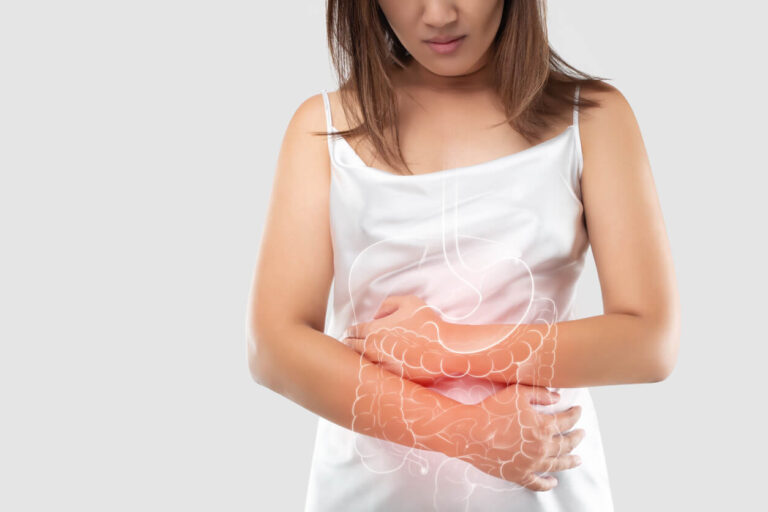 Mulher com dor abdominal, representando os sintomas da disbiose intestinal e desequilíbrio da flora intestinal